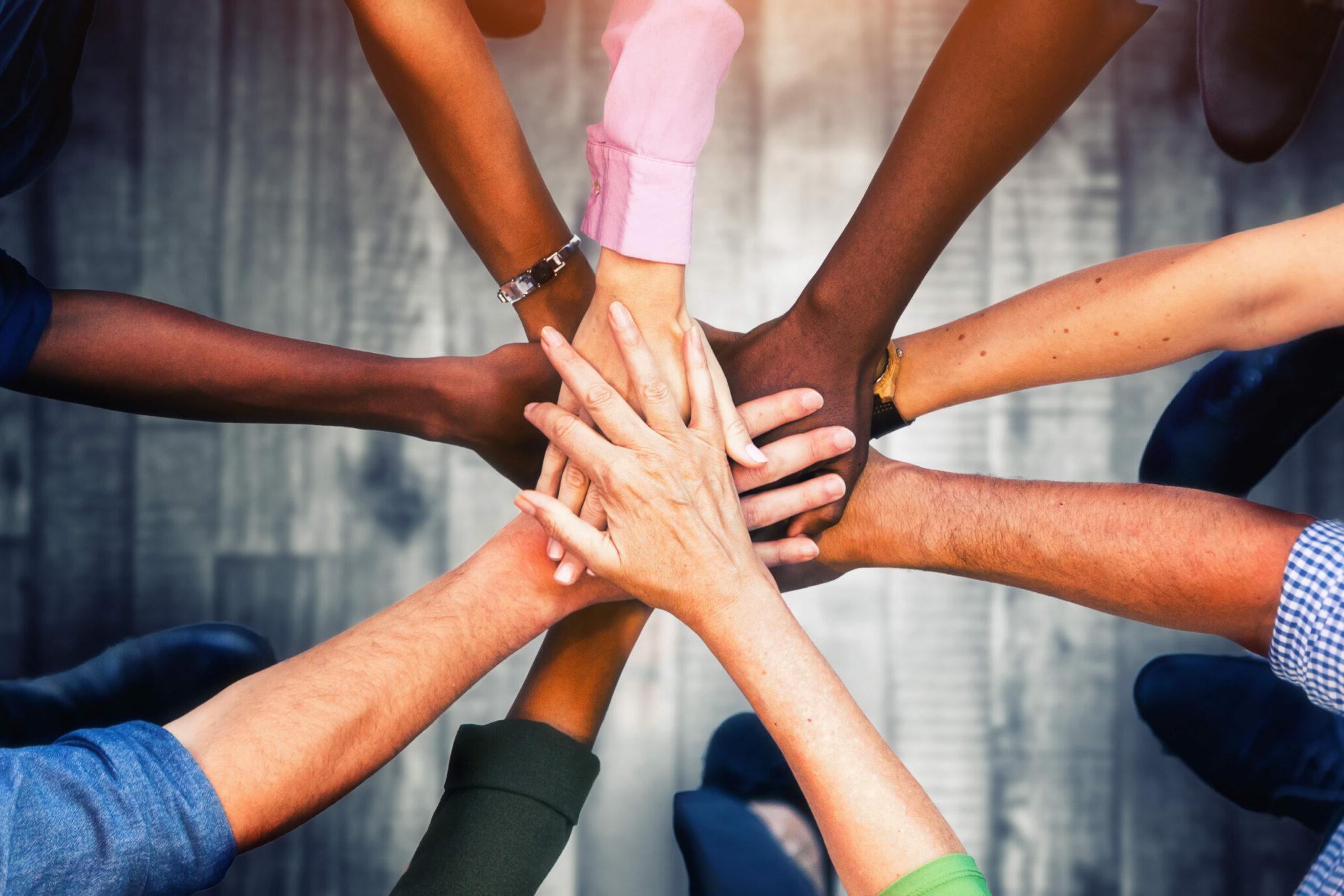 Close up view of young business people putting their hands together. Stack of hands. Unity and teamwork concept.