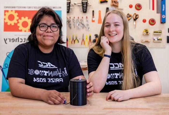 Melanie Cotta 和 Echo Panana photographed in the Hatchery maker space with Hue, a device they invented that identifies colors  for the visually impaired.